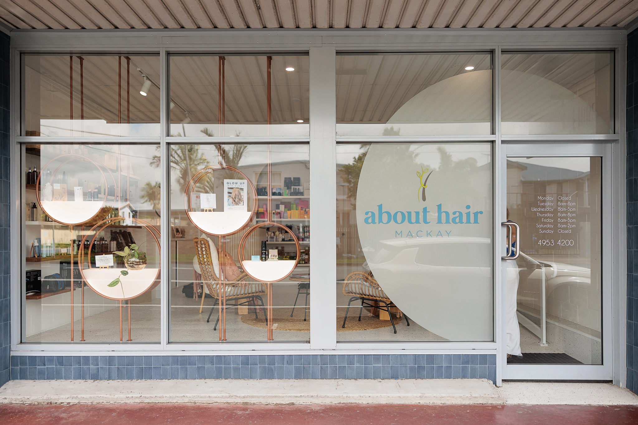 About Hair Mackay salon storefront with organic hair product displays and opening hours